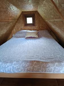 a bed in the middle of a room with a window at Vikendica RANKOVIĆI in Mokra Gora