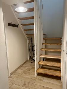 un pasillo con escaleras en una casa con paredes blancas en Cosy room - Maison covoyageurs, en Pessac