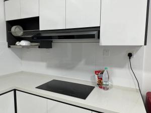 eine Küchentheke mit einer Spüle und einer Mikrowelle in der Unterkunft Montkiara 6Pax YouTube family in Kuala Lumpur