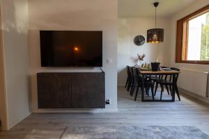 a living room with a large television and a table with chairs at Apartment Naavis in Rovaniemi