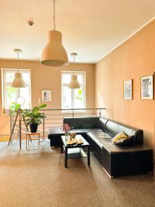 a living room with a black leather couch and a table at Expolis Residence - City Center MTP TARGI- Reception 24h in Poznań