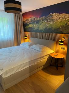 1 dormitorio con 1 cama grande y una pintura en la pared en Pensiunea Padurea Verde, en Moieciu de Sus