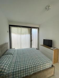 a bedroom with a bed and a window with a television at Crystal in Santo Stefano al Mare