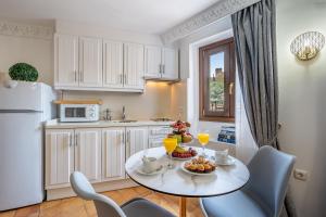 a kitchen with a table with drinks and fruit on it at ADANAR-Apartamentos Muralla Zirí in Granada