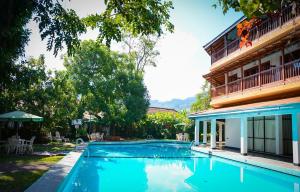 a swimming pool in front of a building at Hotel Hill Top in Kandy