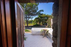 a view from a door of a porch with a table at Dammuso i Pini di Kaddiuggia (CIR19081014C224053) & Dammuso di Mena (CIR 19081014C224052 in Pantelleria