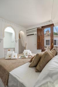 1 dormitorio con 2 camas con almohadas en ADANAR-Apartamentos Muralla Zirí en Granada