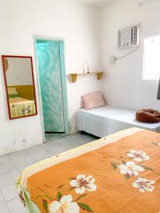 mały pokój z 2 łóżkami i lustrem w obiekcie Hostel Praia de Ondina w mieście Salvador