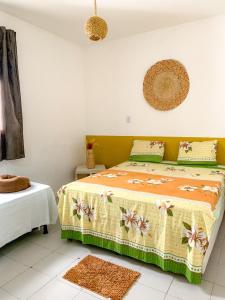 a bedroom with a bed with a floral bedspread at Hostel Praia de Ondina in Salvador