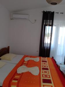 a bedroom with a bed with two white towels on it at Apartman Hana in Donji Štoj