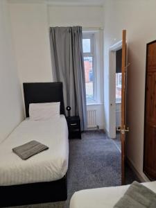 a hotel room with two beds and a window at Luna Apartments Newcastle Gateshead 3 in Gateshead