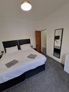 a bedroom with a large bed and a mirror at Luna Apartments Newcastle Gateshead 3 in Gateshead