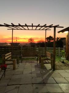 a group of benches sitting under a pavilion at sunset at Casa de Campo in Guaíba