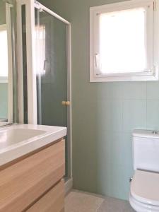 La salle de bains est pourvue d'un lavabo, de toilettes et d'une fenêtre. dans l'établissement Magnífica casa con vistas al mar y piscina privada, à Gérone