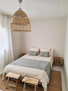 a bedroom with a large bed with two wooden stools at Magnífica casa con vistas al mar y piscina privada in Girona