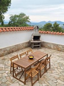 a patio with a table and chairs and a grill at Magnífica casa con vistas al mar y piscina privada in Girona