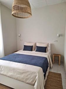 - une chambre avec un grand lit et des oreillers bleus dans l'établissement Magnífica casa con vistas al mar y piscina privada, à Gérone