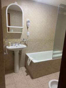 La salle de bains est pourvue d'un lavabo, d'une baignoire et de toilettes. dans l'établissement Mirando al Sur, à Ushuaia