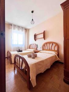 1 dormitorio con 2 camas y ventana en Casa Yolanda, en Ávila