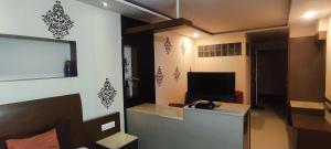 um quarto com uma secretária e uma televisão num quarto em Happy Vibes studio flats - service apartment em Mysore