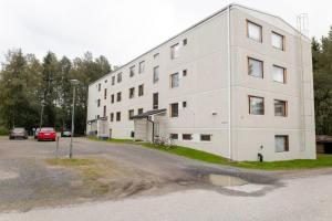 un edificio bianco con un parcheggio accanto di Apartment Naavis a Rovaniemi