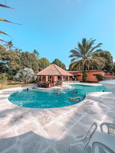 a swimming pool with a gazebo in a resort at Eco Pousada Paraíso dos Coqueirais in Japaratinga