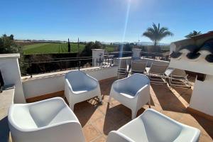 a group of chairs on a balcony with a view at Villa Alegre - 2 bed villa with private heated pool on Mar Menor Golf - family friendly in Torre-Pacheco