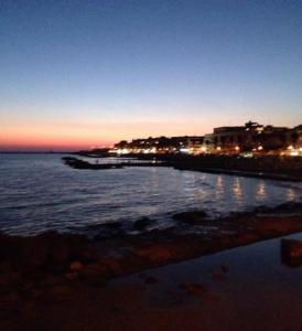 - une vue sur l'océan la nuit avec une jetée dans l'établissement Tripoli, à Anzio