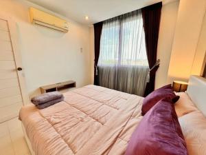 a bedroom with a large bed and a window at EXCESSIVELY 1 Bedroom in Amazon Condo in Jomtien Beach +15 photos
