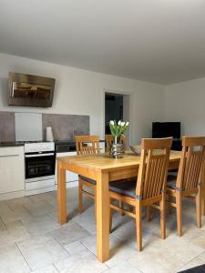 a kitchen with a wooden table and four chairs at Schönes Apartment / Ferienwohnung am Regen in Blaibach