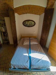 un letto in una stanza con un dipinto sul muro di CASA DI LUCA a Stezzano