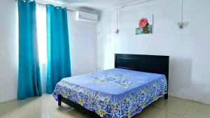 een slaapkamer met een bed met een blauwe deken bij White Residence in Quatre Bornes