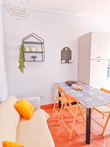 - un salon avec une table et des chaises dans l'établissement Wanderlust Sicily appartamento "Mare", à Oliveri
