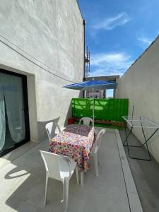 a patio with a table and chairs and a blue umbrella at Crystal in Santo Stefano al Mare