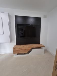 Una sala de estar con un televisor en la pared. en Casa Casco Antiguo, en Linares