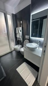 a large bathroom with two sinks and a toilet at Sole apartments in Shëngjin