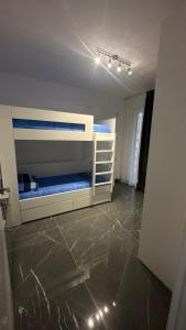 a bedroom with two bunk beds and a tile floor at Sole apartments in Shëngjin