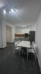 a dining room with a table and chairs and a kitchen at Sole apartments in Shëngjin