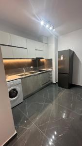 a kitchen with a stove and a sink and a refrigerator at Sole apartments in Shëngjin