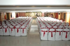 a row of white chairs with red bows on them at Hotel Sitara Residency in Hyderabad