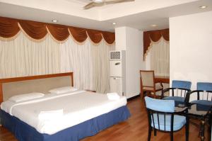 a bedroom with a bed and a table and chairs at Hotel Sitara Residency in Hyderabad