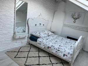 a white bedroom with a bed and a mirror at Les coeurs brisés in Crans-Montana