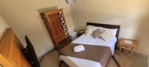 a bedroom with a large bed with a wooden headboard at Pousada Império in Serra do Cipo