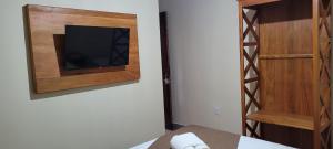 a room with a tv on a wall with a door at Pousada Império in Serra do Cipo