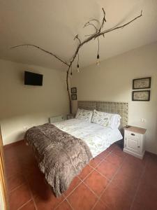 um quarto com uma cama e um ramo pendurado no tecto em El Sueño de Valcabe em Cardaño de Abajo