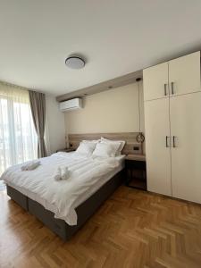 a bedroom with a large bed with towels on it at Vila Simfonija with Free parking in Vrnjačka Banja
