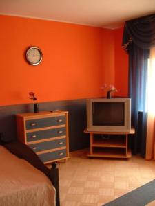 a bedroom with an orange wall and a tv at Savi Guest Apartments in Tartu