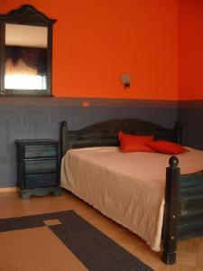 a bedroom with a bed and an orange wall at Savi Guest Apartments in Tartu