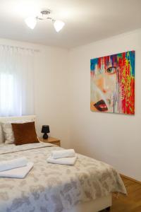 una camera da letto con un letto e un quadro sul muro di Apartman HILL 1 a Golubac