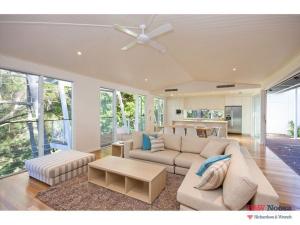 a living room with a couch and a ceiling fan at 14a Little Cove Road, Little Cove in Noosa Heads